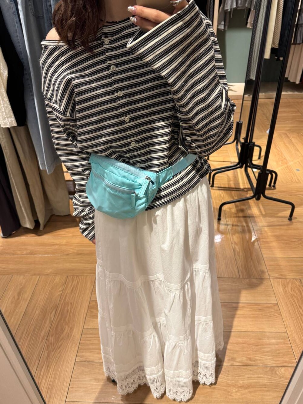 ブラック系のパンプス、ブルー系のボディバッグ/ウエストポーチ、グレー系のカーディガン/ボレロを着用したレディースの春コーディネートの2枚目の写真