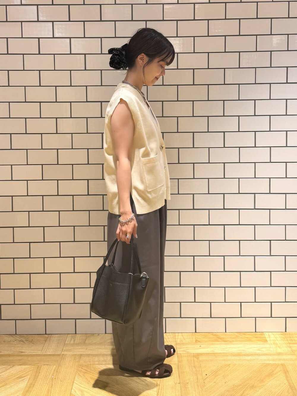 シルバー系のタンクトップ、グレー系のその他パンツ、ブラウン系のサンダルを着用したレディースの夏コーディネートの3枚目の写真