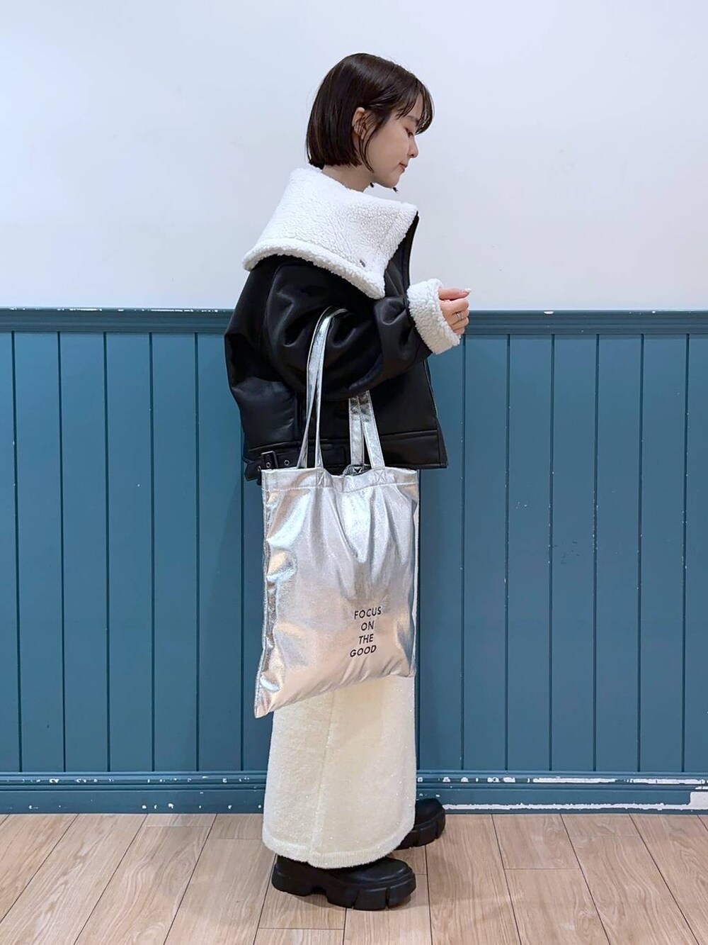 ブラック系のブーツ、シルバー系のトートバッグ、ブルー系のTシャツ/カットソーを着用したレディースの冬コーディネートの3枚目の写真