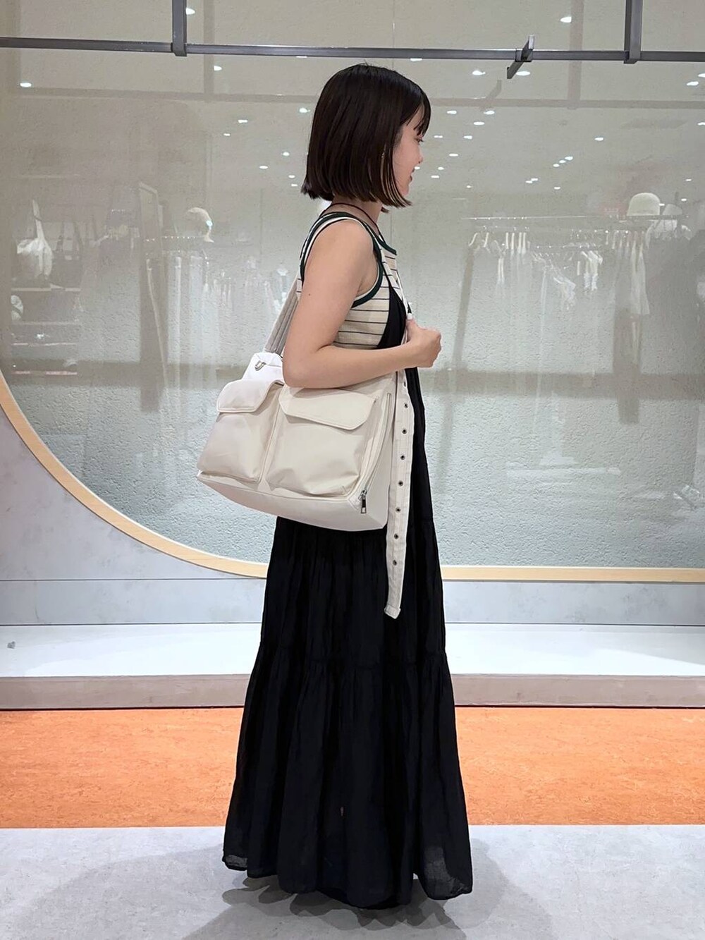 ベージュ系のタンクトップ、ホワイト系のTシャツ/カットソー、ブラック系のサンダルを着用したレディースの夏コーディネートの2枚目の写真