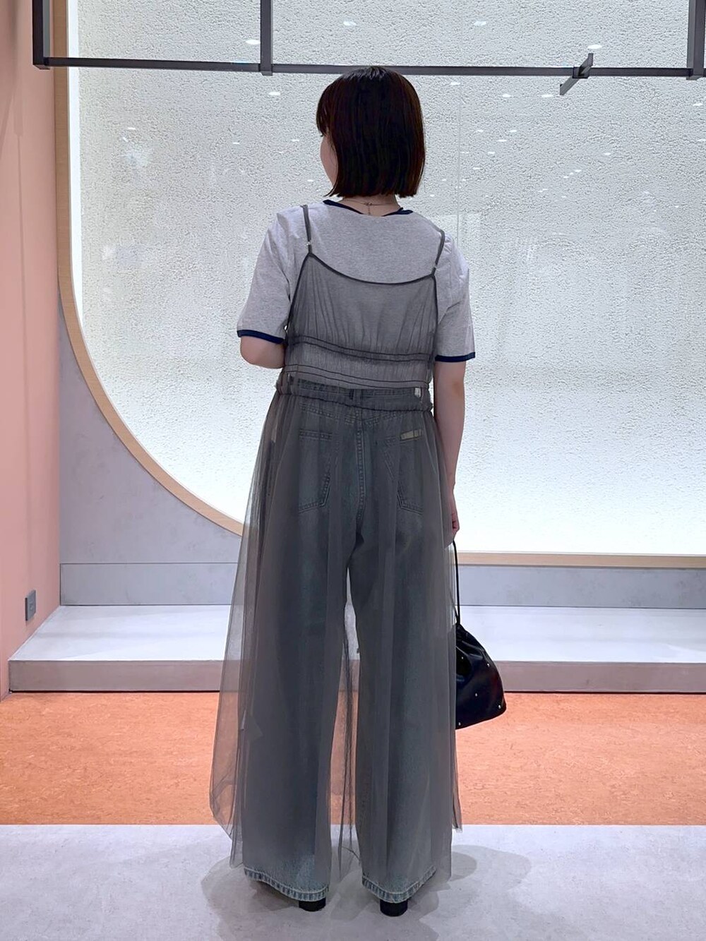 ブラック系のショルダーバッグ、グレー系のTシャツ/カットソー、ブルー系のデニムパンツを着用したレディースの夏コーディネートの4枚目の写真