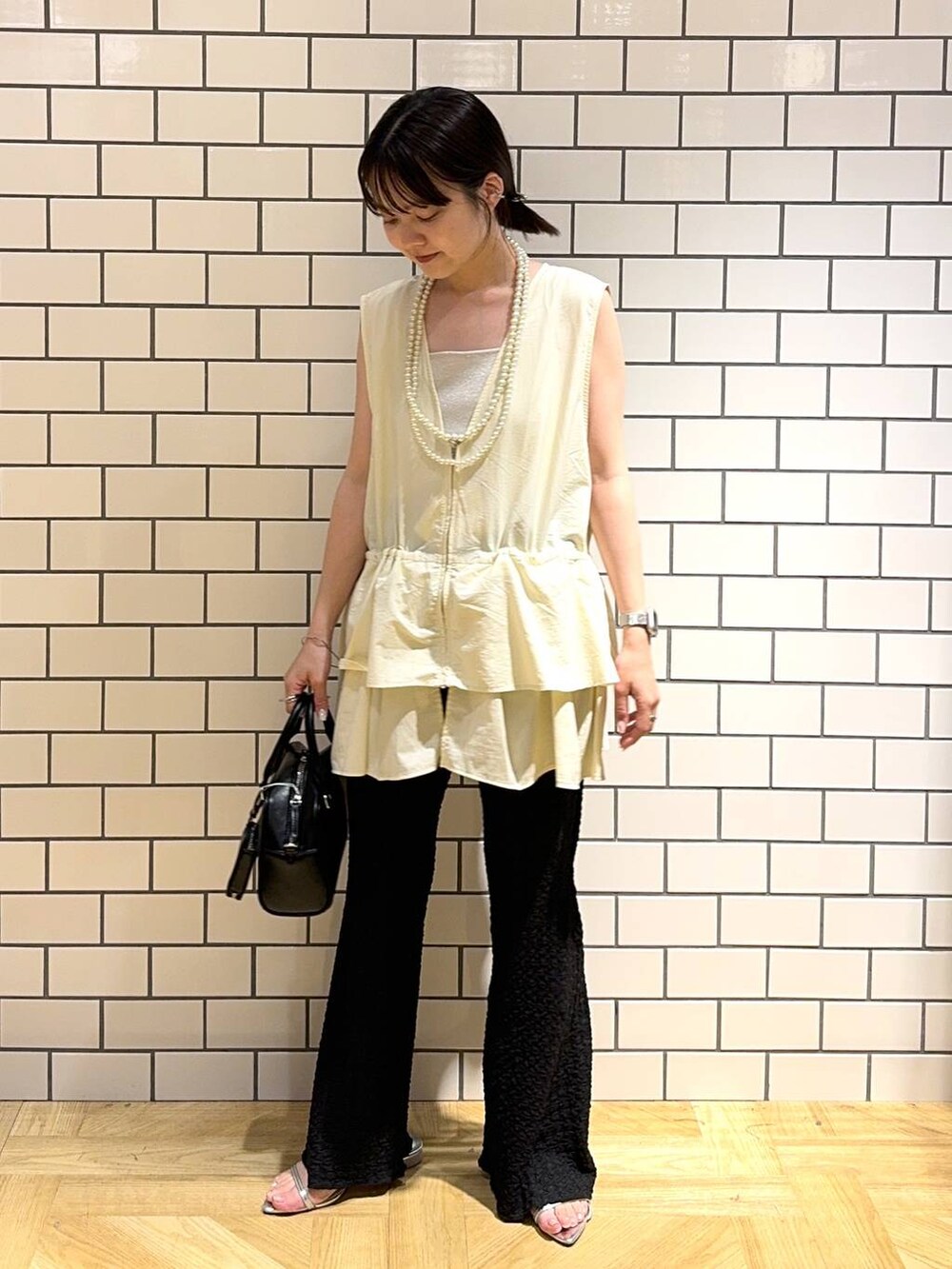 シルバー系のサンダル、シルバー系のタンクトップ、ブラック系のその他パンツを着用したレディースの夏コーディネートの2枚目の写真