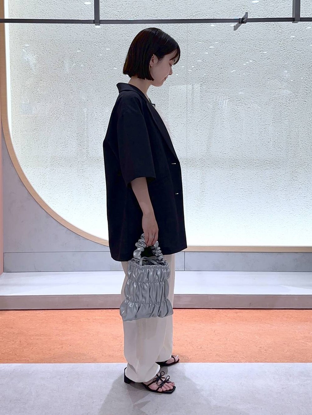 ホワイト系のカーゴパンツ、ブラック系のサンダル、ホワイト系のTシャツ/カットソーを着用したレディースの夏コーディネートの2枚目の写真