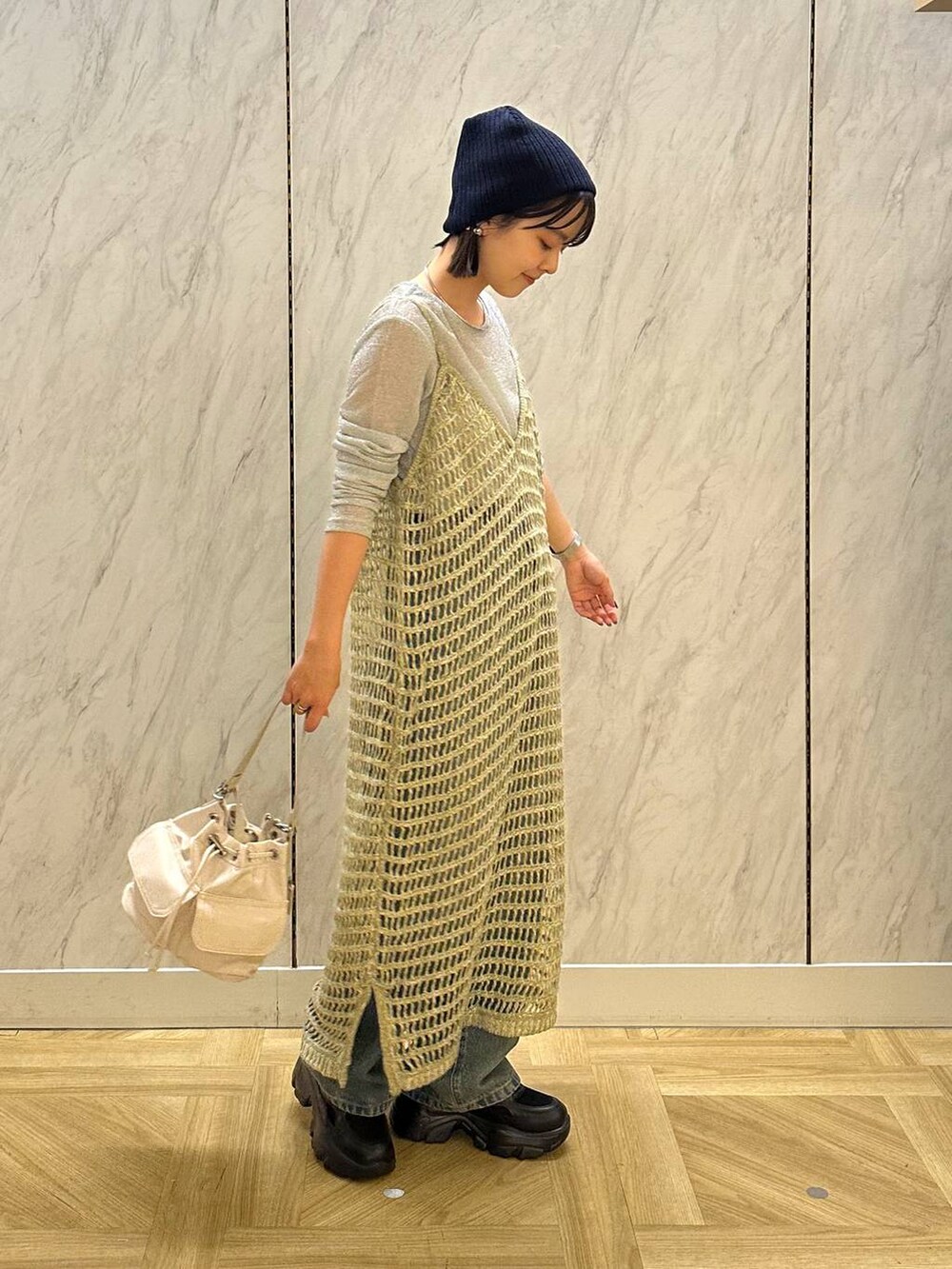 シルバー系のTシャツ/カットソー、ブラック系のスニーカー、ブルー系のデニムパンツを着用したレディースの秋コーディネートの3枚目の写真