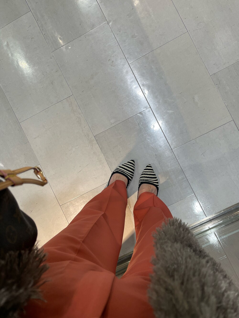 グレー系のノーカラージャケット、ピンク系のスラックス、その他のシューズを着用したレディースの秋コーディネートの3枚目の写真