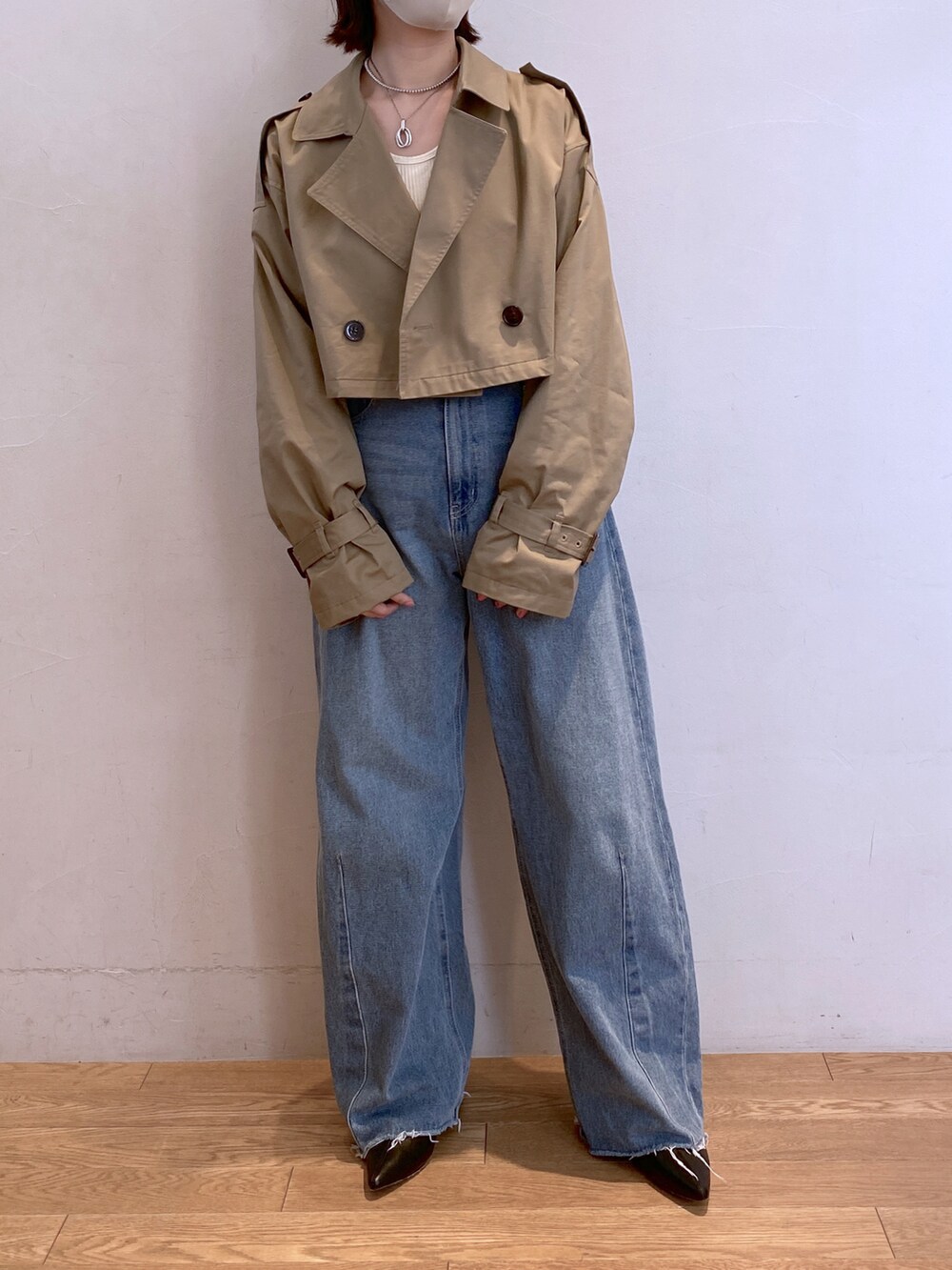 ブルー系のデニムパンツ、ベージュ系のトレンチコートを着用したレディースの秋コーディネートの2枚目の写真