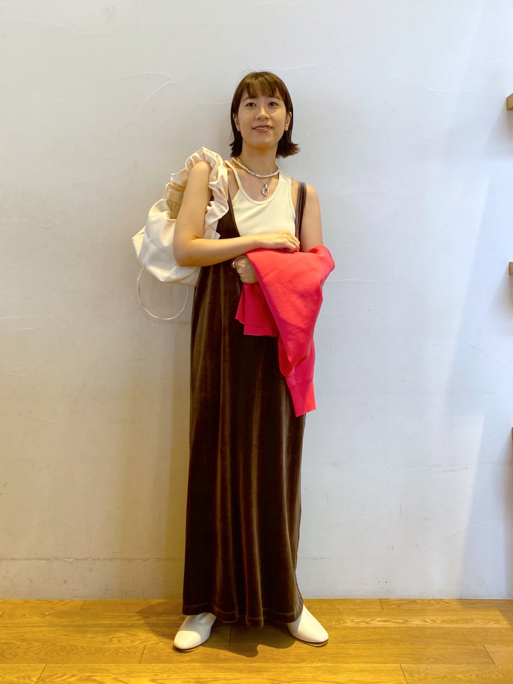 ピンク系のカーディガン/ボレロ、ベージュ系のワンピース、ホワイト系のブーツを着用したレディースの秋コーディネートの2枚目の写真