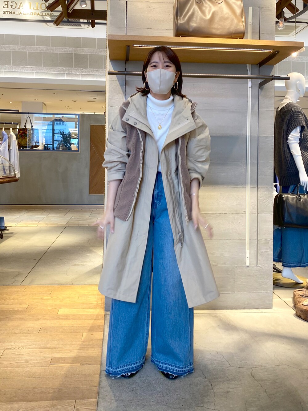 ベージュ系のその他アウター、ホワイト系のニット/セーター、ブラウン系のショルダーバッグを着用したレディースの秋コーディネートの2枚目の写真