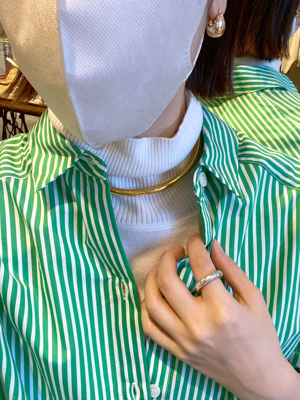 グリーン系のシャツ/ブラウス、ホワイト系のスカート、ホワイト系のニット/セーターを着用したレディースの冬コーディネートの2枚目の写真