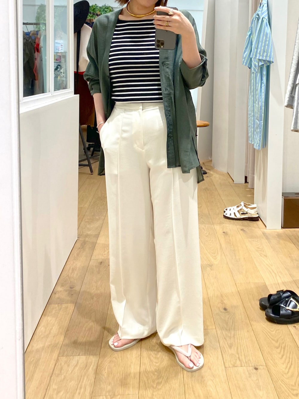 ブラック系のキャミソール、グリーン系のシャツ/ブラウス、ホワイト系のスラックスを着用したレディースの夏コーディネートの2枚目の写真