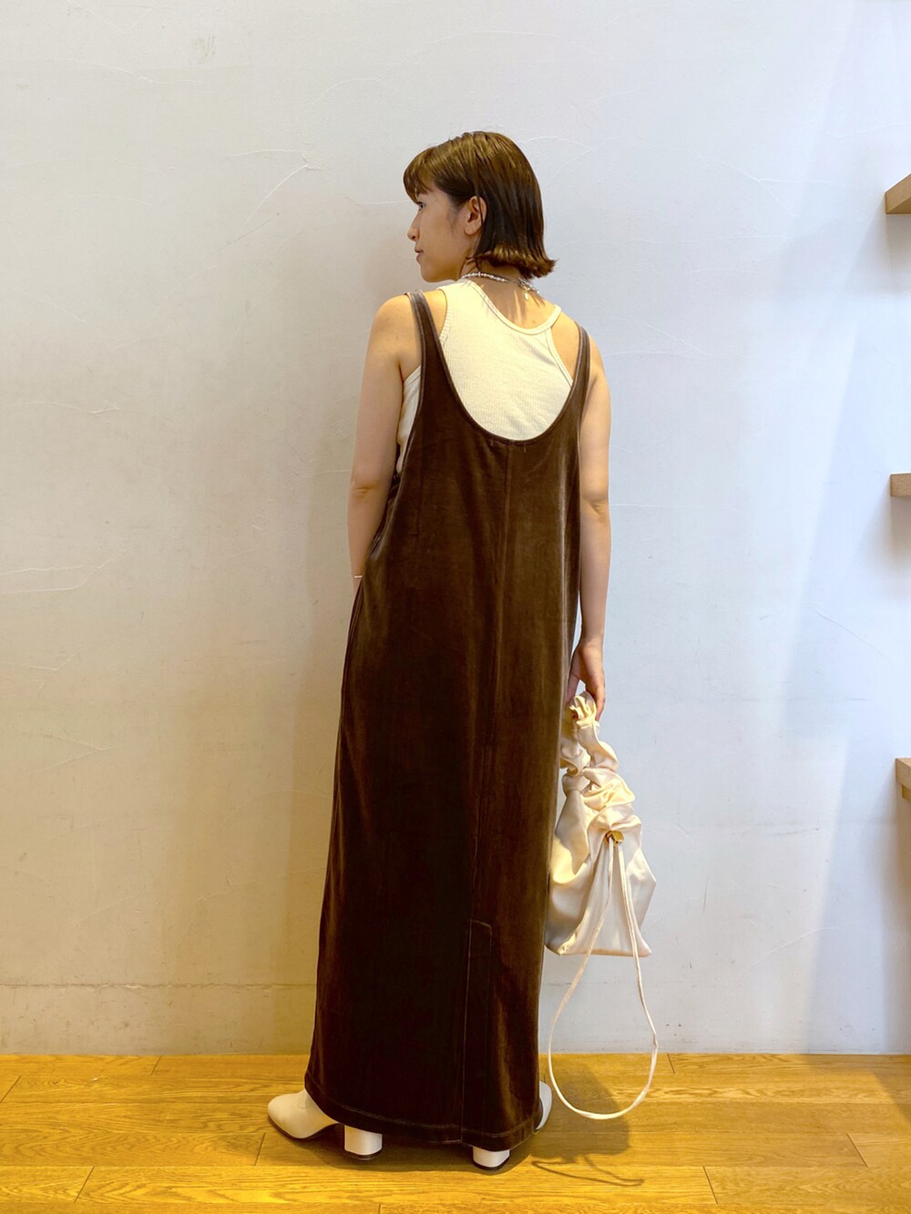 ピンク系のカーディガン/ボレロ、ベージュ系のワンピース、ホワイト系のブーツを着用したレディースの秋コーディネートの3枚目の写真