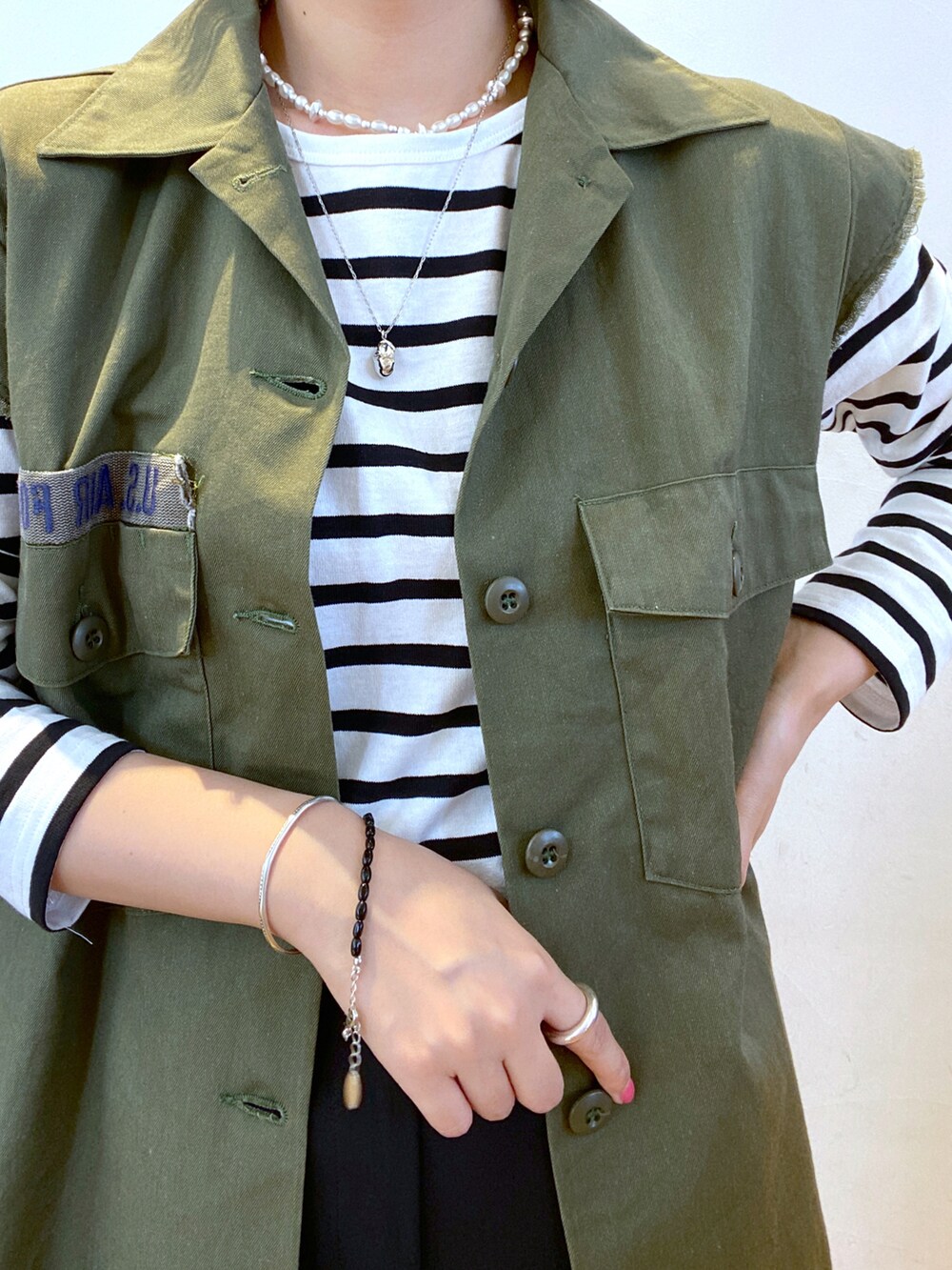 ブラック系のスラックス、ブラック系のショルダーバッグ、ブラック系のサンダルを着用したレディースの夏コーディネートの2枚目の写真