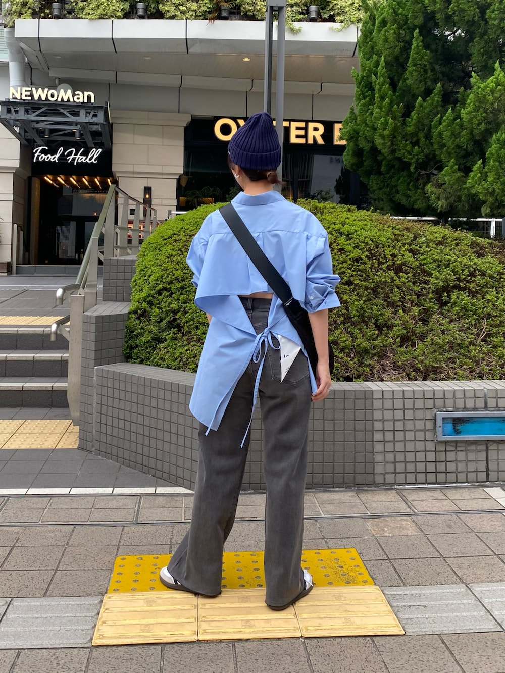 ブルー系のシャツ/ブラウス、ブラック系のショルダーバッグ、グレー系のデニムパンツを着用したレディースの秋コーディネートの2枚目の写真