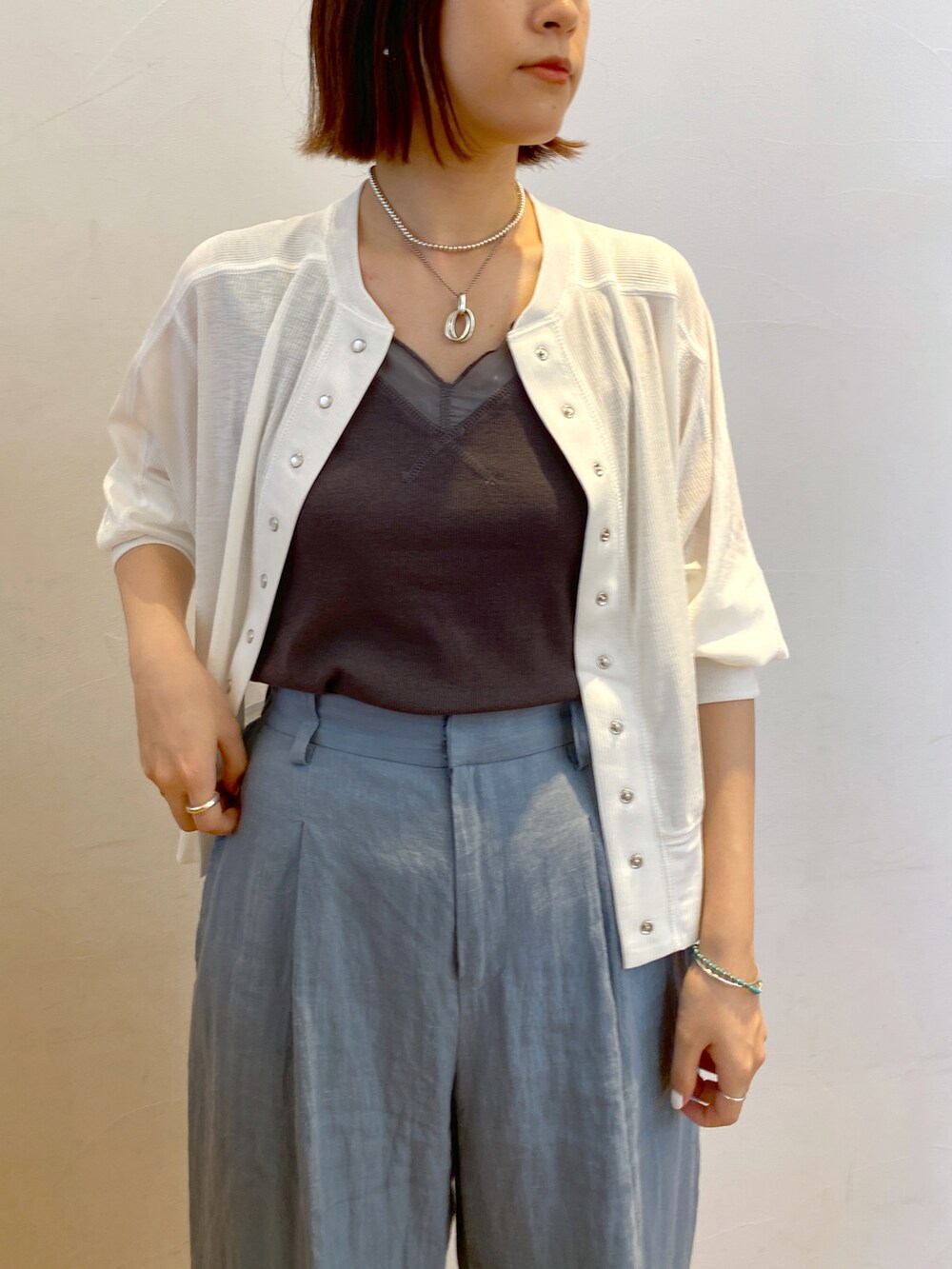 グレー系のタンクトップ、ホワイト系のカーディガン/ボレロ、ブルー系のその他パンツを着用したレディースの夏コーディネートの2枚目の写真