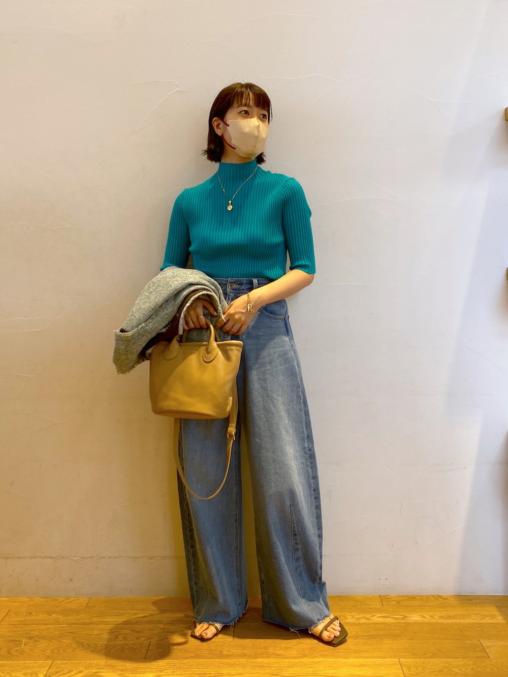 グリーン系のニット/セーター、ブルー系のノーカラージャケット、ブルー系のデニムパンツを着用したレディースの夏コーディネートの2枚目の写真