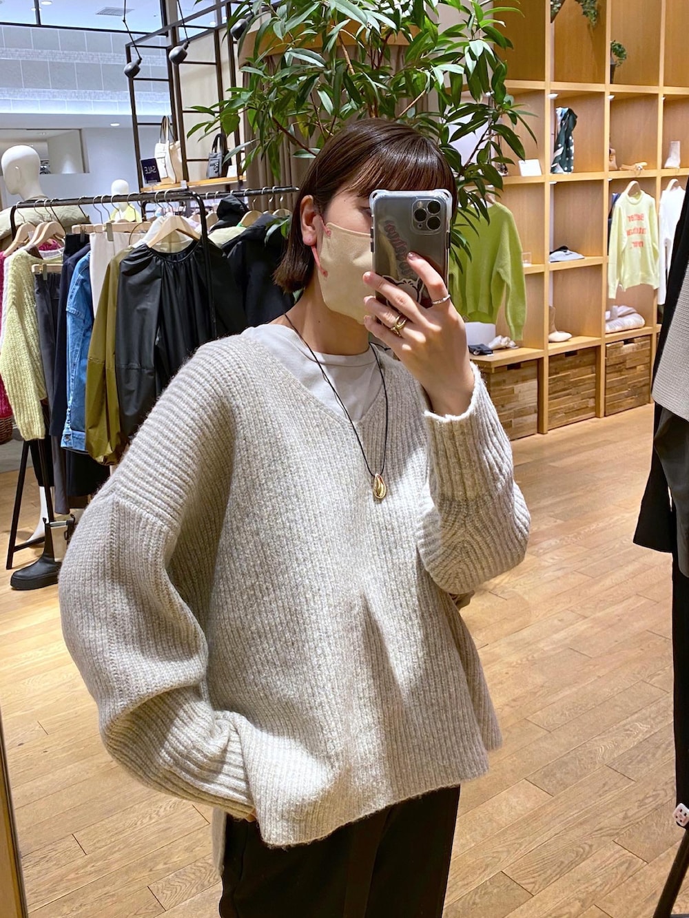 ブラック系のスラックス、グレー系のニット/セーター、ピンク系のTシャツ/カットソーを着用したレディースの冬コーディネートの2枚目の写真