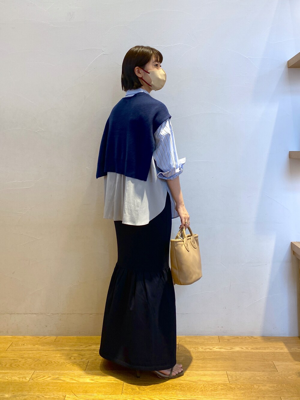 ブラウン系のトートバッグ、ブルー系のシャツ/ブラウス、ブルー系のスカートを着用したレディースの夏コーディネートの2枚目の写真