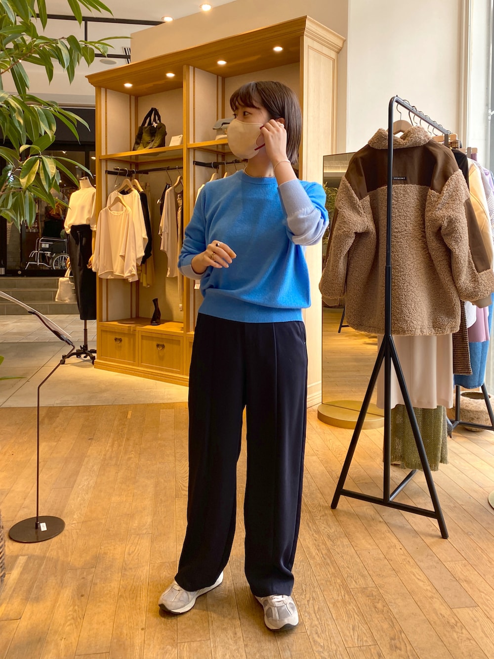 グレー系のその他アウター、ブルー系のスラックス、ブルー系のニット/セーターを着用したレディースの秋コーディネートの2枚目の写真