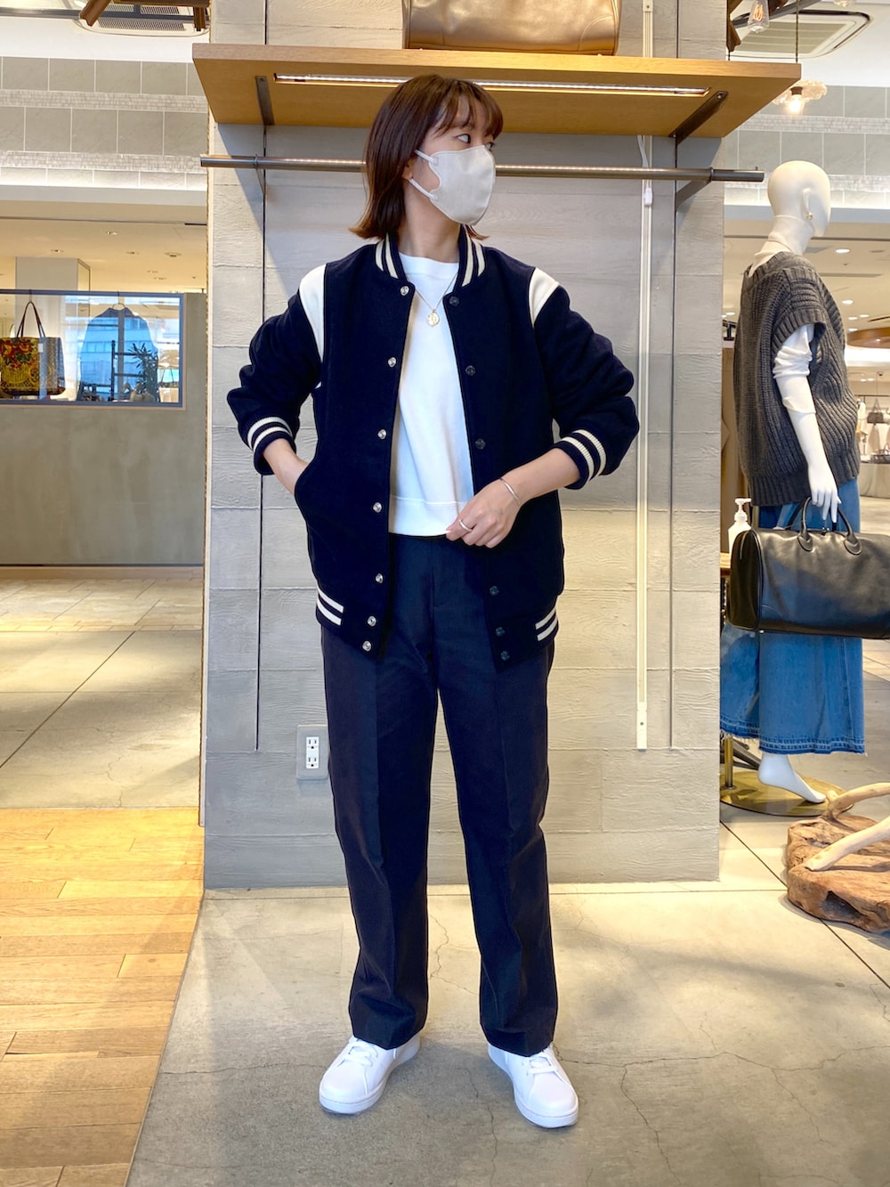 ホワイト系のスウェット、ブルー系のベスト、ブルー系のチノパンツを着用したレディースの秋コーディネートの2枚目の写真