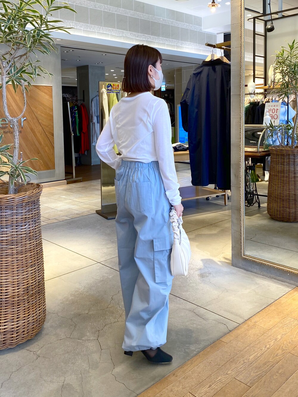 ホワイト系のTシャツ/カットソー、ブルー系のカーゴパンツ、ホワイト系のハンドバッグを着用したレディースの冬コーディネートの2枚目の写真