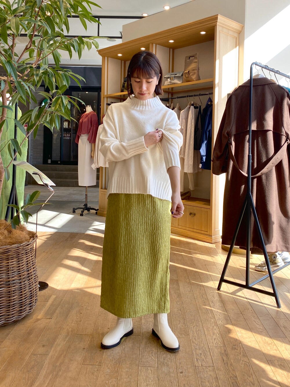 ホワイト系のダウンジャケット/コート、ホワイト系のニット/セーター、グリーン系のスカートを着用したレディースの秋コーディネートの2枚目の写真