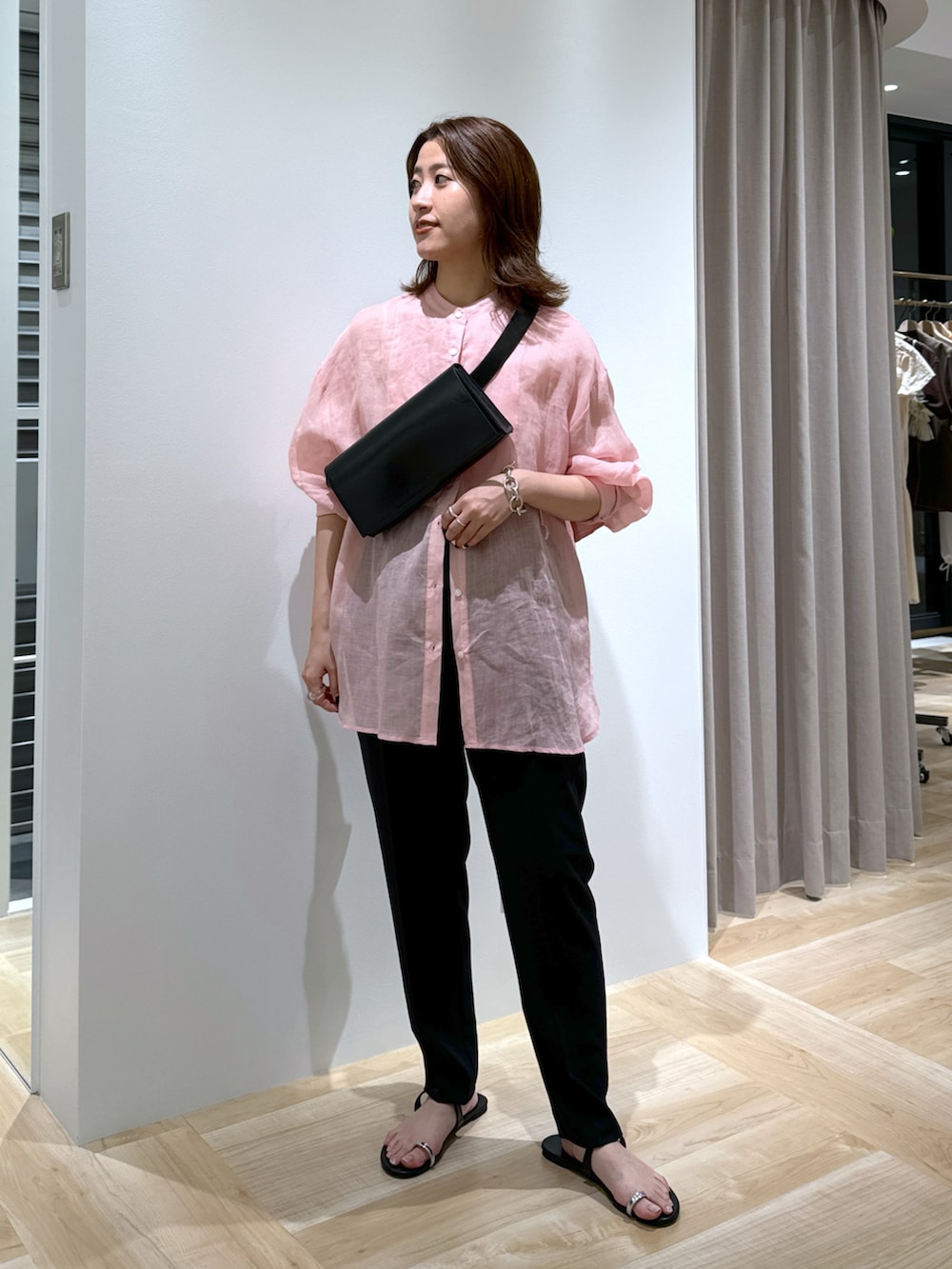 ピンク系のシャツ/ブラウス、ブラック系のスラックス、ブラック系のサンダルを着用したレディースの春コーディネートの2枚目の写真