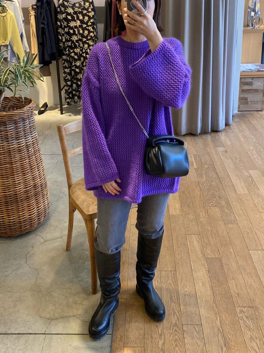 パープル系のニット/セーター、グレー系のデニムパンツ、ブラック系のショルダーバッグを着用したレディースの秋コーディネートの2枚目の写真