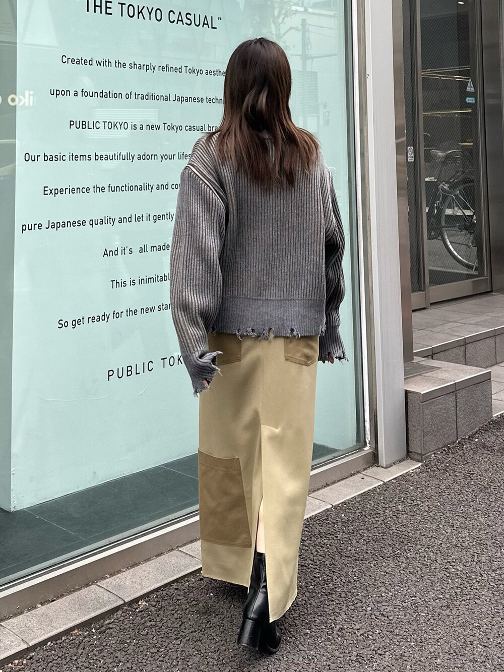 ベージュ系のスカート、グレー系のニット/セーターを着用したレディースの冬コーディネートの2枚目の写真