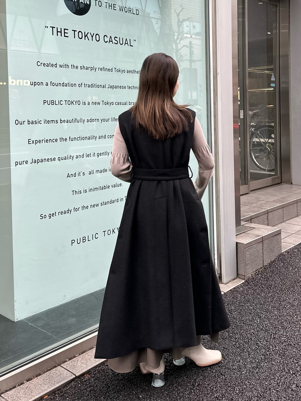 グレー系のワンピース、ブラック系のステンカラーコートを着用したレディースの秋コーディネートの4枚目の写真