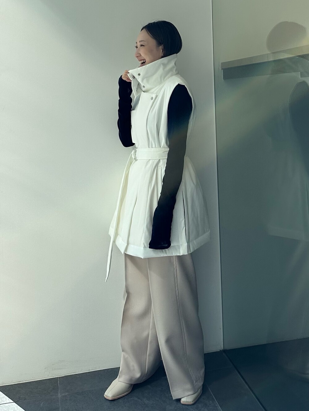 ベージュ系のダウンベスト、ブラック系のTシャツ/カットソー、ベージュ系のその他パンツを着用したレディースの秋コーディネートの3枚目の写真