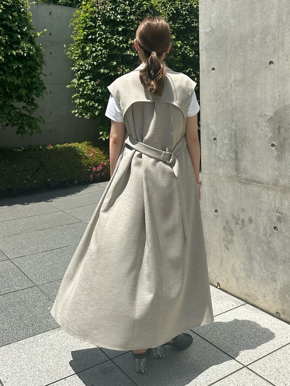 ゴールド系のスカート、ベージュ系のワンピース、ホワイト系のTシャツ/カットソーを着用したレディースの春コーディネートの4枚目の写真