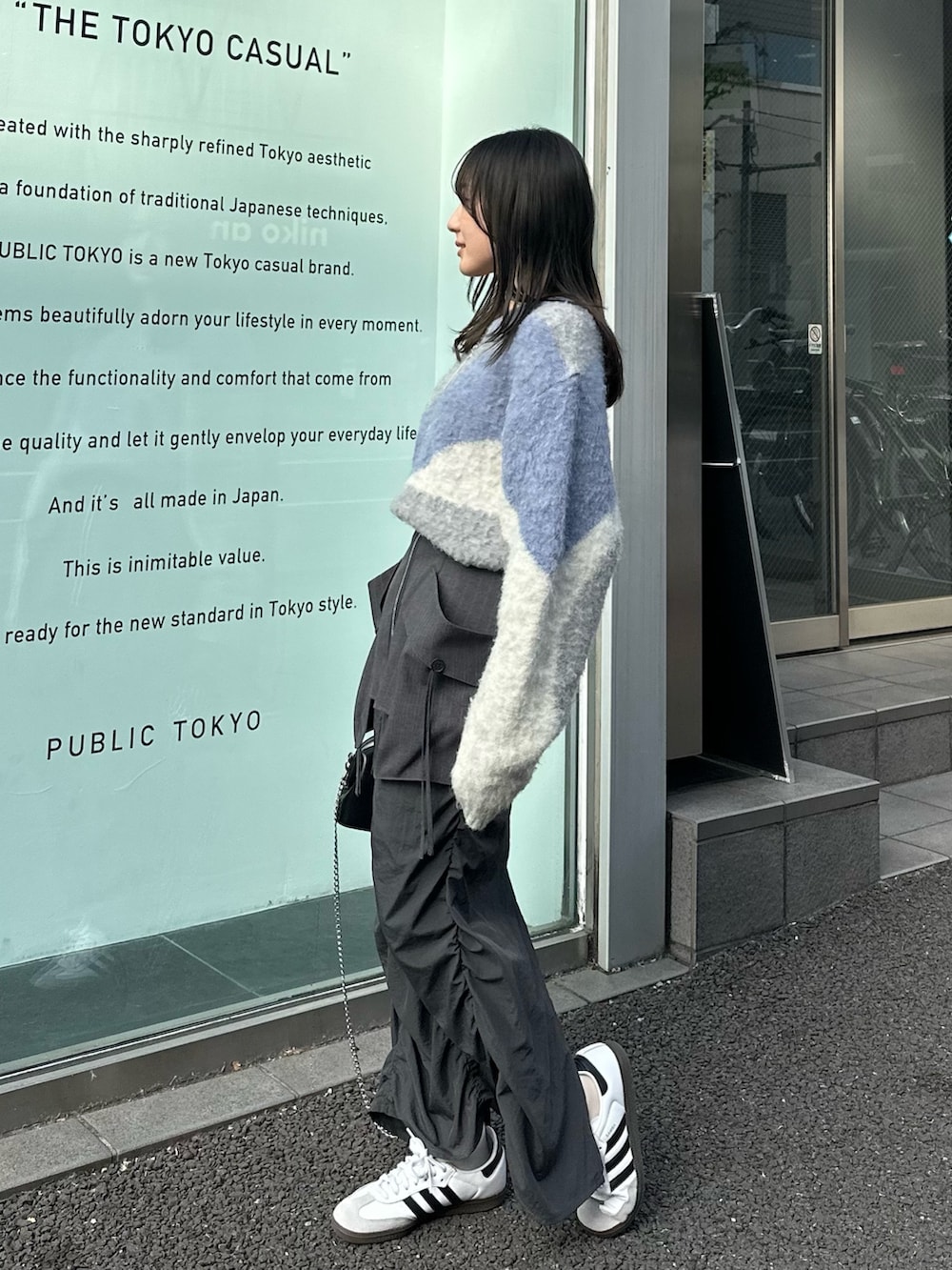 グレー系のスカート、グレー系のニット/セーター、ブラック系のハンドバッグを着用したレディースの冬コーディネートの2枚目の写真