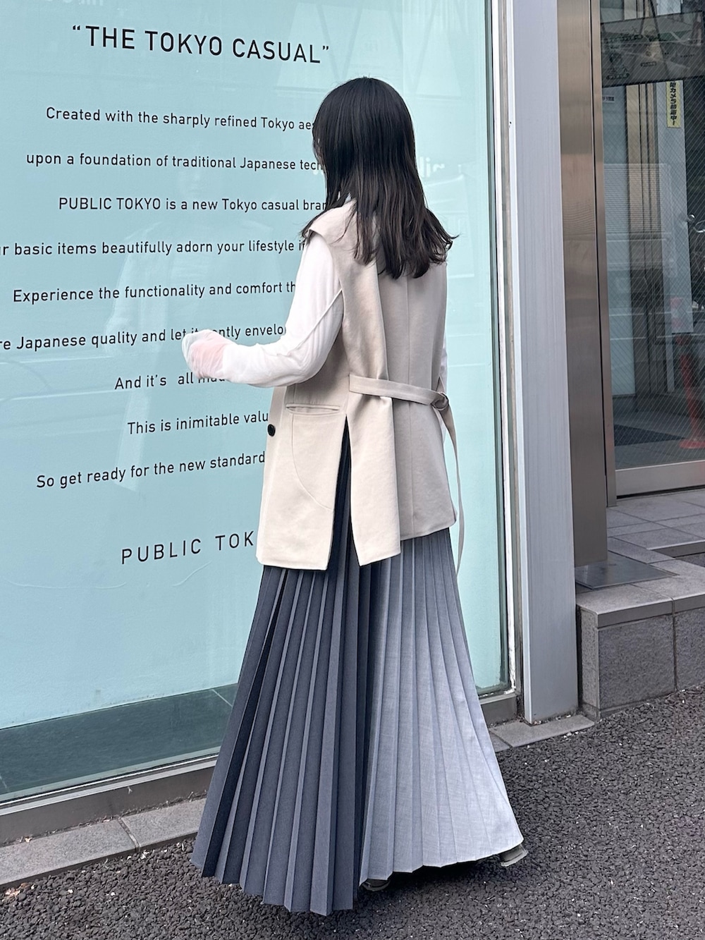 グレー系のスカート、ベージュ系のベストを着用したレディースの冬コーディネートの2枚目の写真