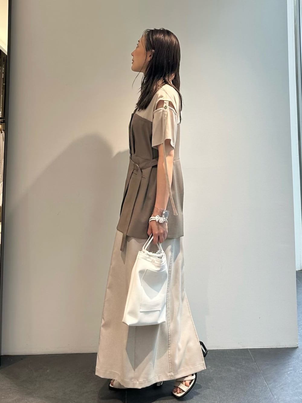 ベージュ系のワンピースを着用したレディースの夏コーディネートの2枚目の写真