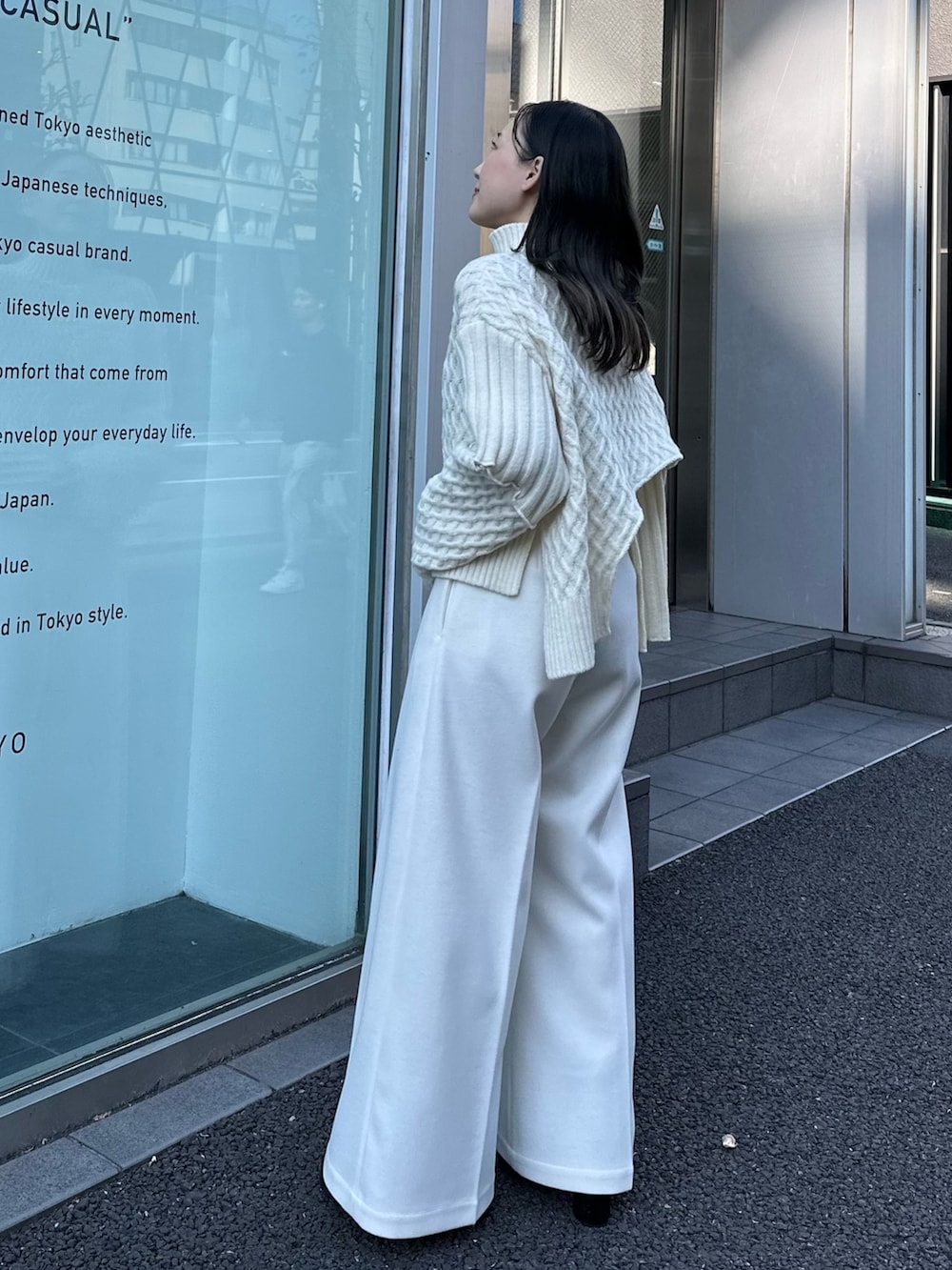 ベージュ系のニット/セーター、ベージュ系のスラックスを着用したレディースの秋コーディネートの3枚目の写真