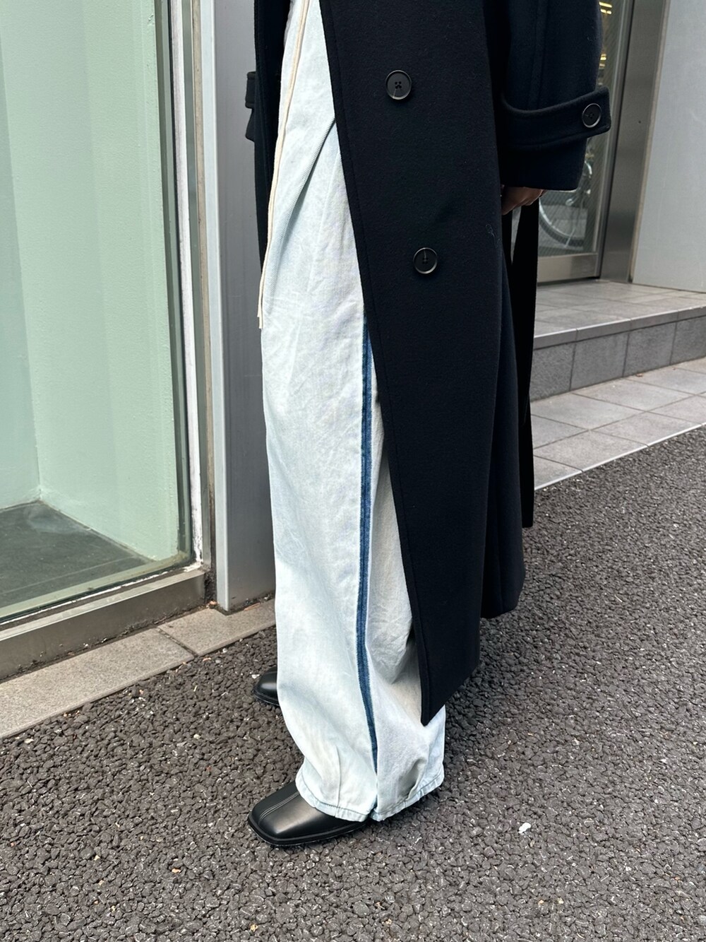 ブラック系のチェスターコートを着用したレディースの秋コーディネートの5枚目の写真