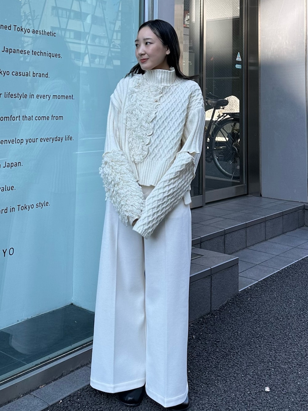 ベージュ系のニット/セーター、ベージュ系のスラックスを着用したレディースの秋コーディネートの2枚目の写真