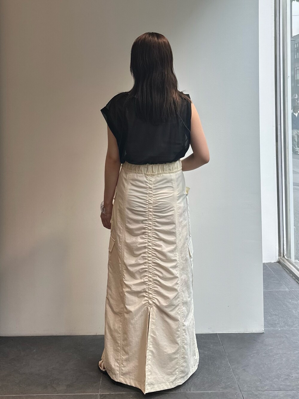 ブラック系のTシャツ/カットソー、ブラック系のベスト、ホワイト系のスカートを着用したレディースの夏コーディネートの7枚目の写真