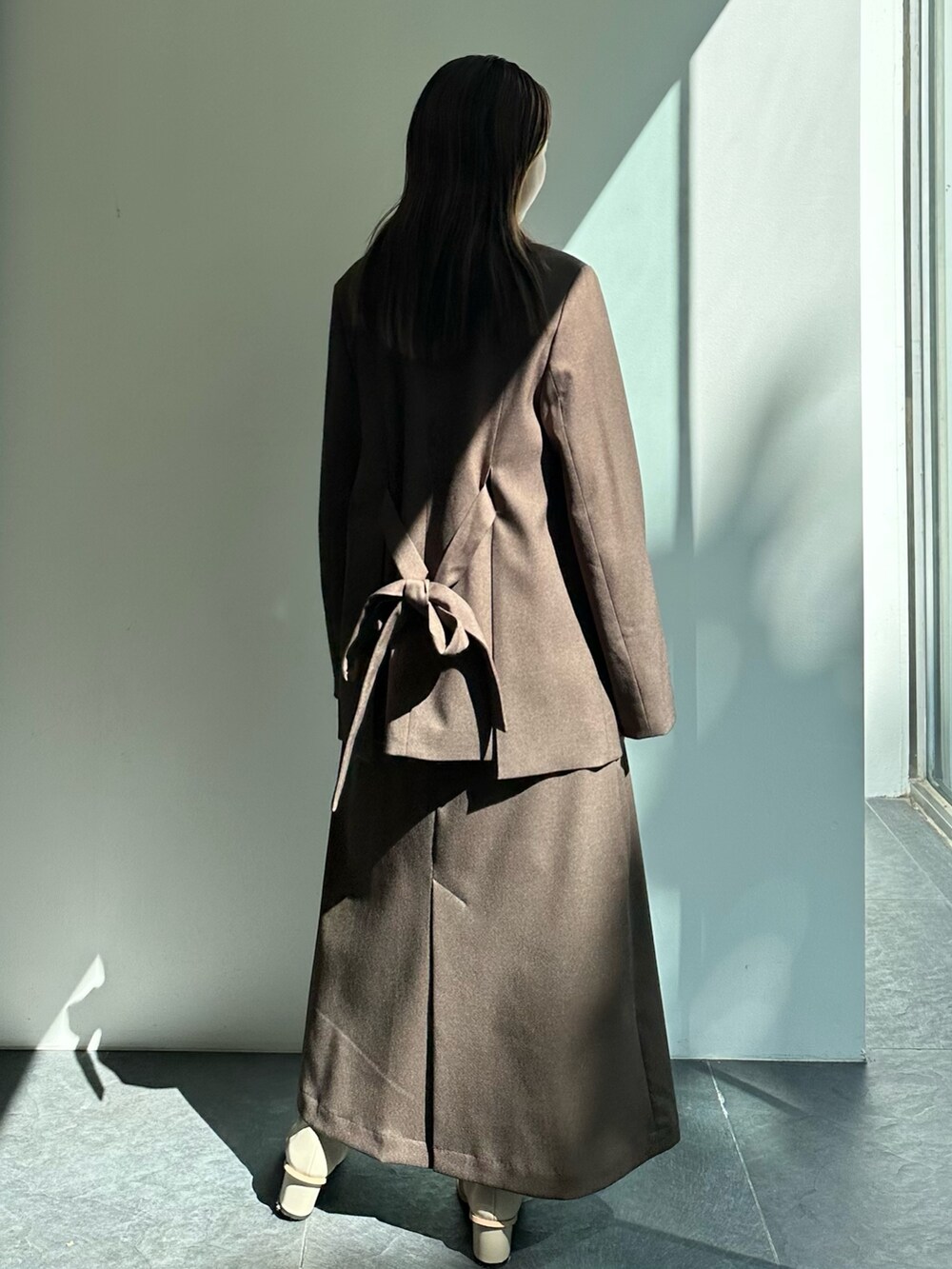 ブラウン系のテーラードジャケット、ブラウン系のスカートを着用したレディースの秋コーディネートの5枚目の写真