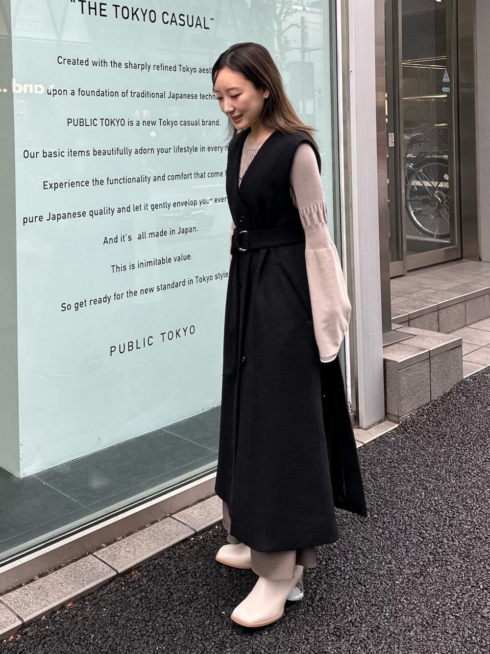 グレー系のワンピース、ブラック系のステンカラーコートを着用したレディースの秋コーディネートの3枚目の写真