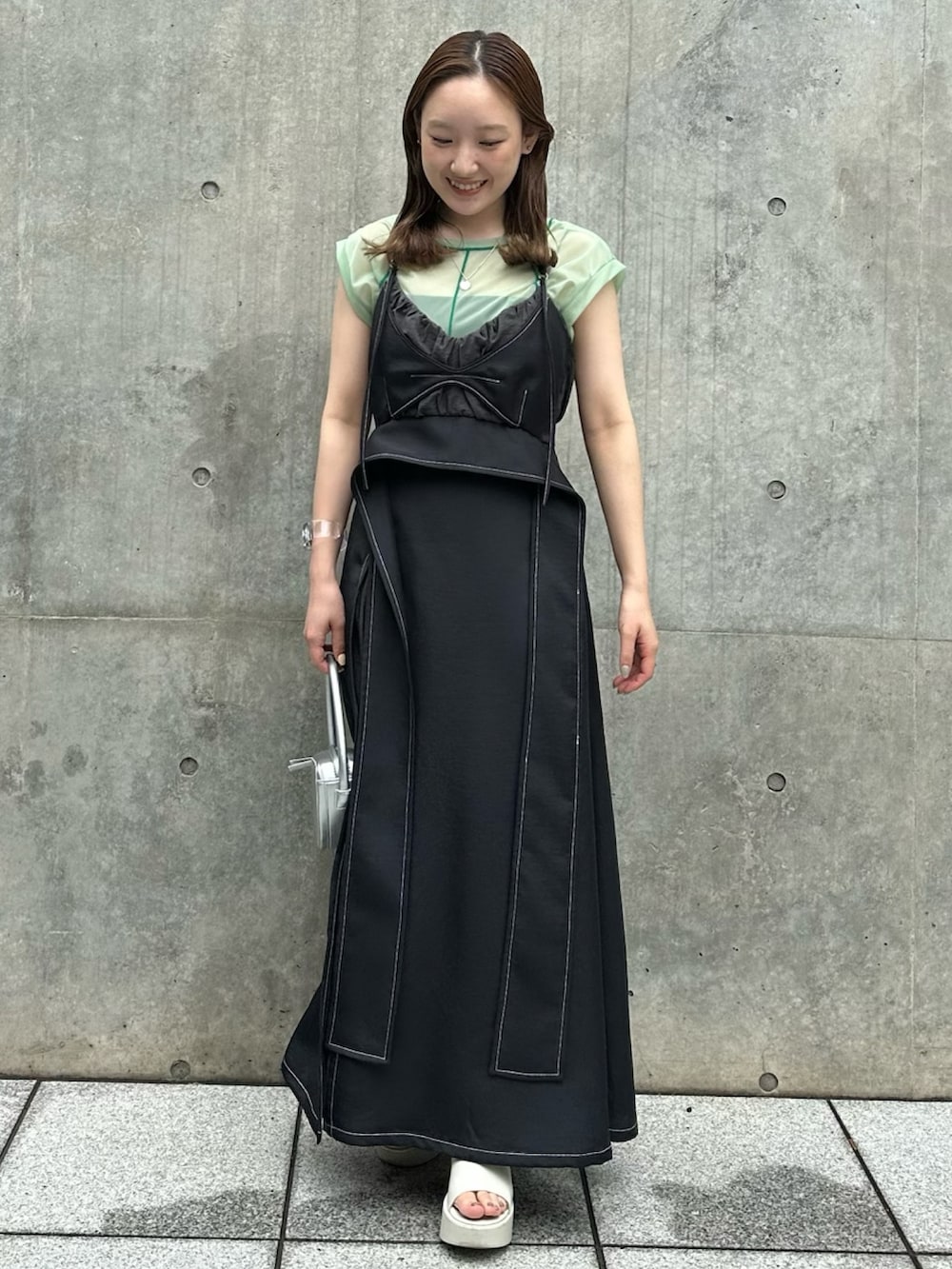 ブラック系のワンピース、グリーン系のTシャツ/カットソー、シルバー系のハンドバッグを着用したレディースの夏コーディネートの2枚目の写真