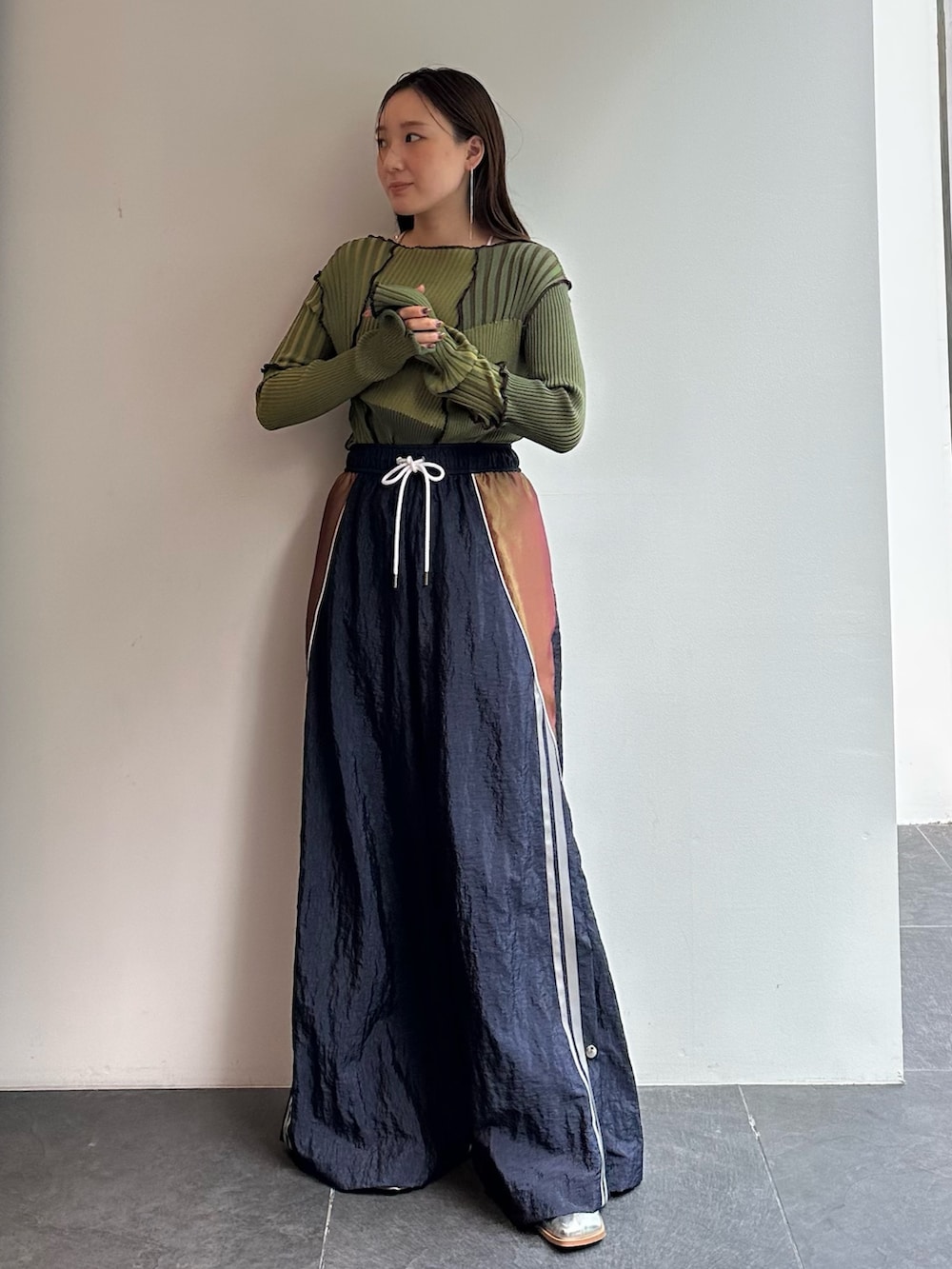 グリーン系のニット/セーター、ブルー系のその他パンツを着用したレディースの秋コーディネートの2枚目の写真