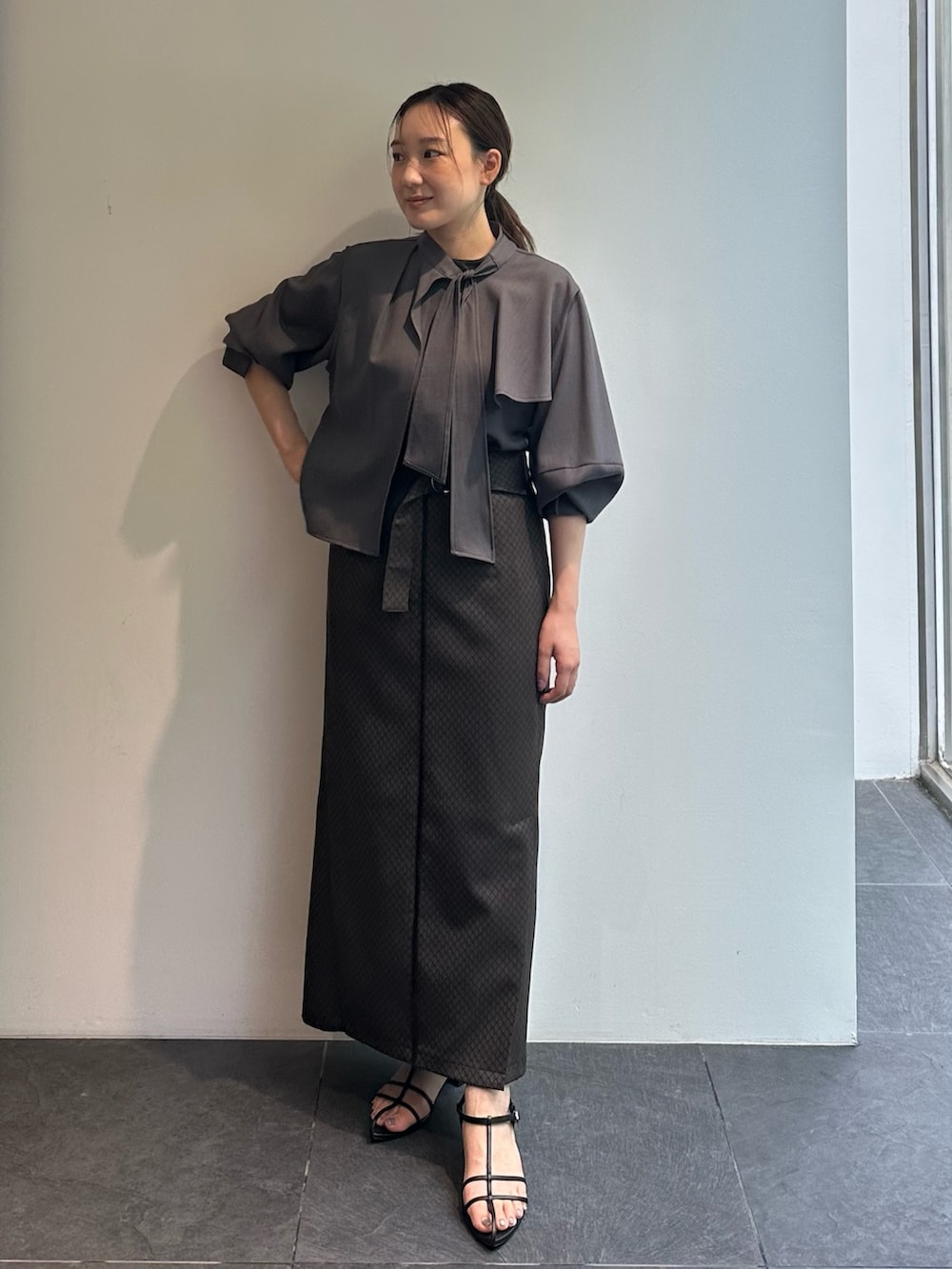 グレー系のシャツ/ブラウス、ブラウン系のスカートを着用したレディースの秋コーディネートの2枚目の写真