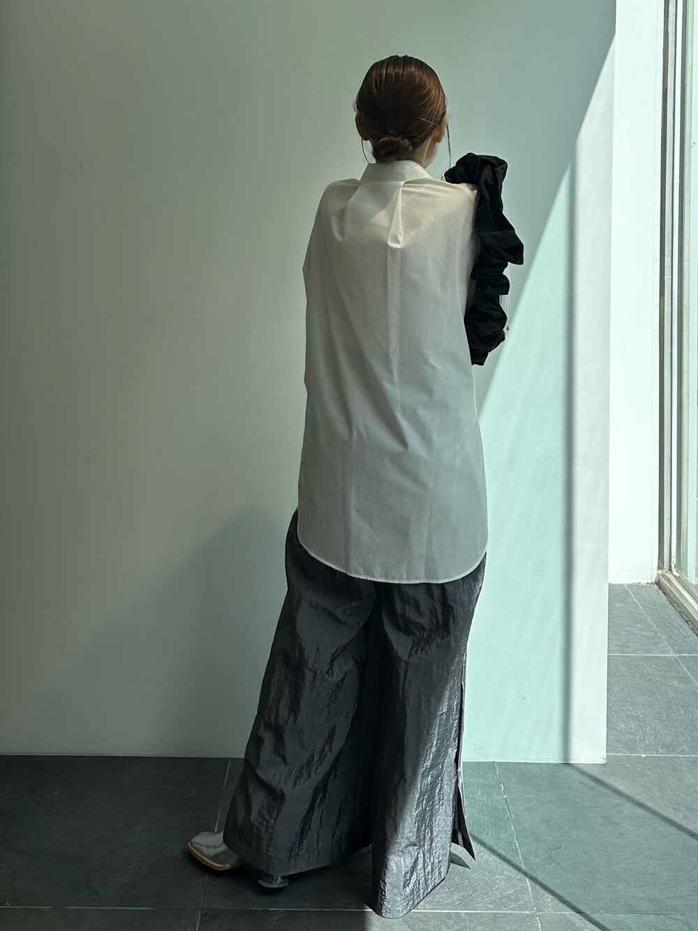 ブラック系のショルダーバッグ、ホワイト系のシャツ/ブラウス、グレー系のその他パンツを着用したレディースの秋コーディネートの4枚目の写真