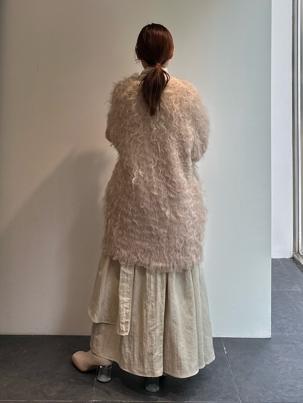 ホワイト系のTシャツ/カットソー、ベージュ系のスカート、ベージュ系のカーディガン/ボレロを着用したレディースの秋コーディネートの5枚目の写真