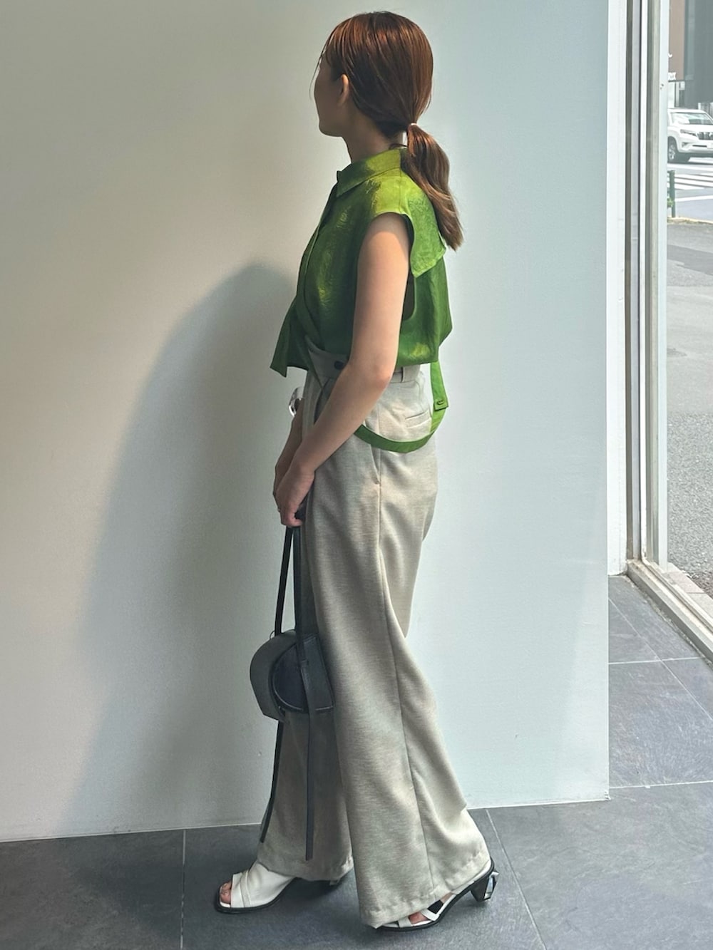 グリーン系のシャツ/ブラウス、ベージュ系のスラックスを着用したレディースの夏コーディネートの2枚目の写真