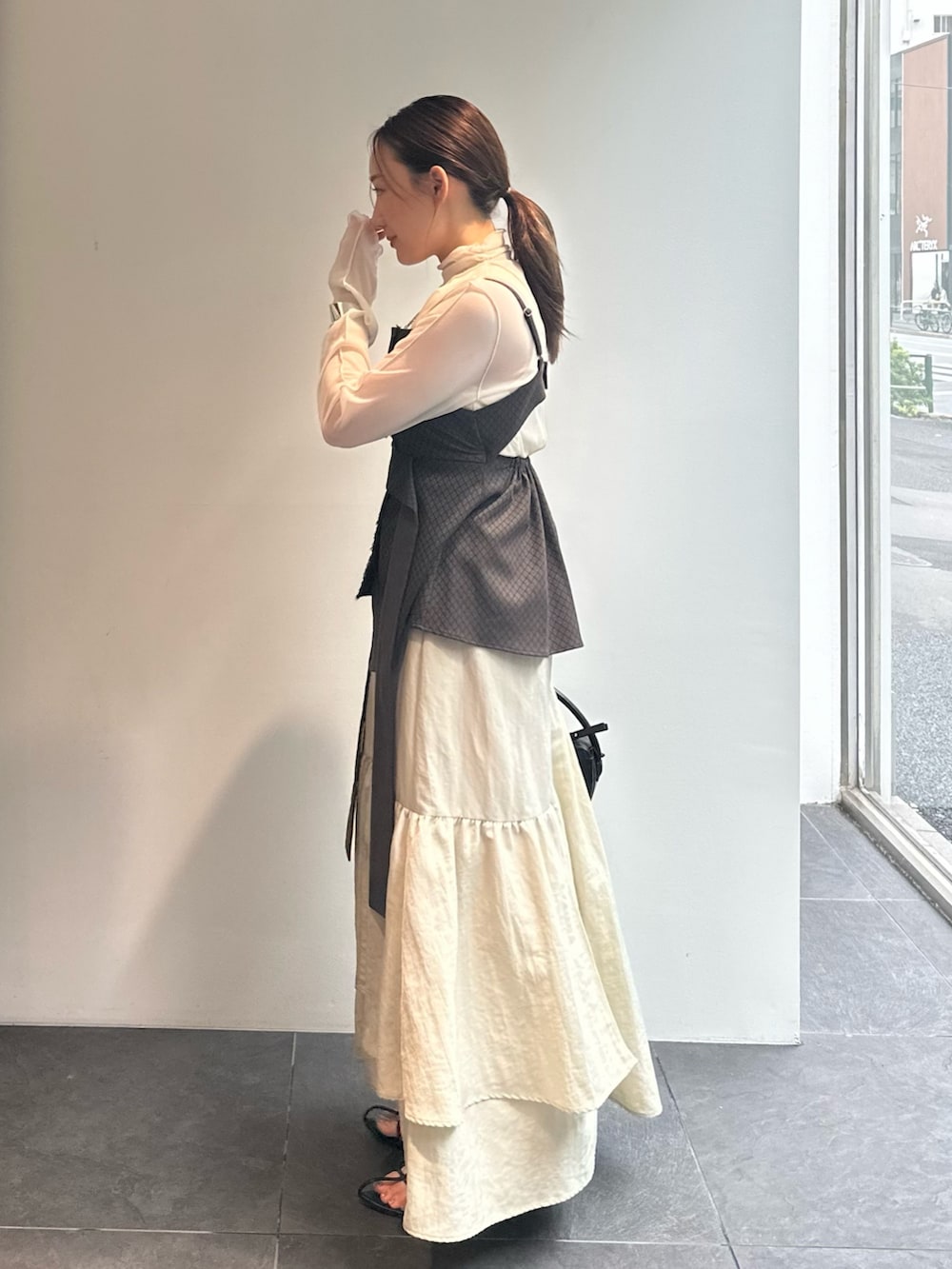 ホワイト系のTシャツ/カットソー、ブラウン系のキャミソール、ベージュ系のスカートを着用したレディースの秋コーディネートの2枚目の写真