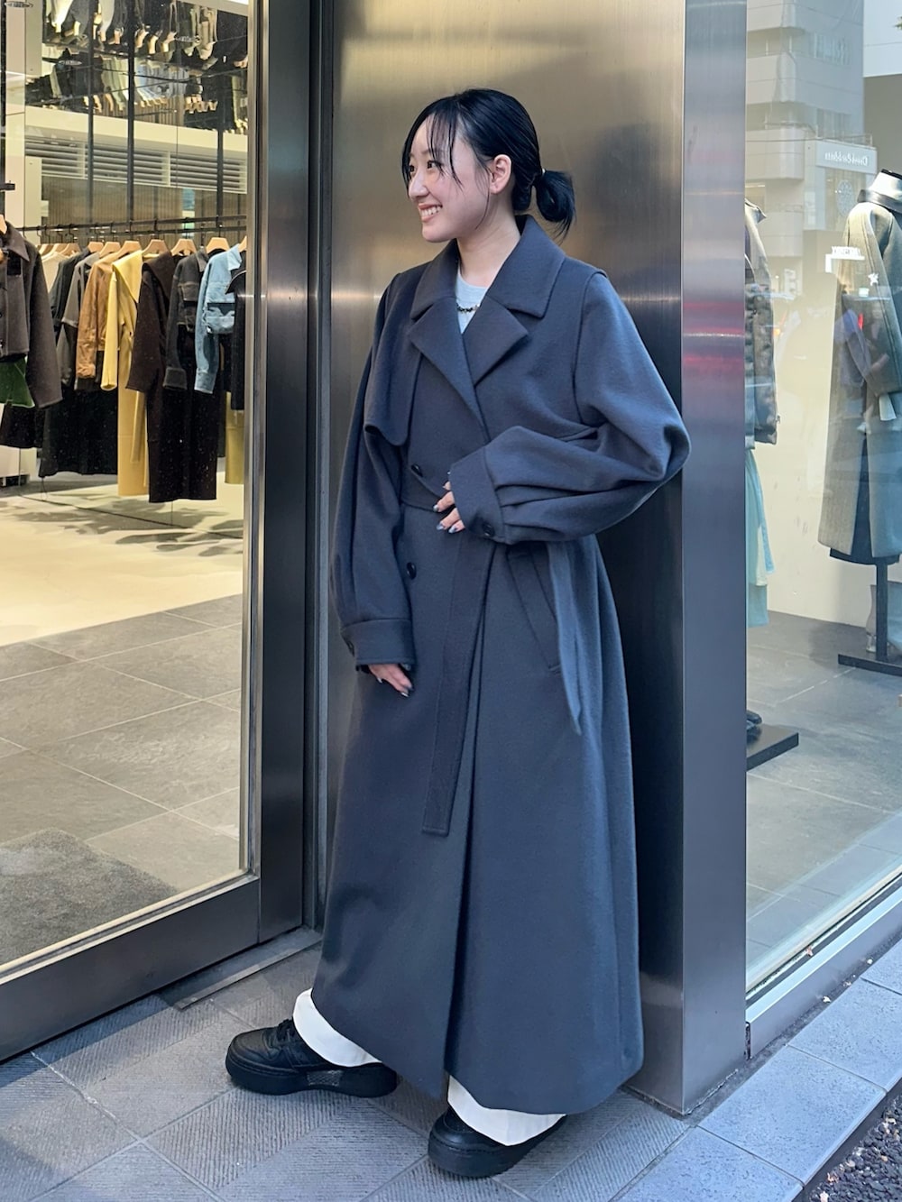 グレー系のステンカラーコートを着用したレディースの秋コーディネートの4枚目の写真