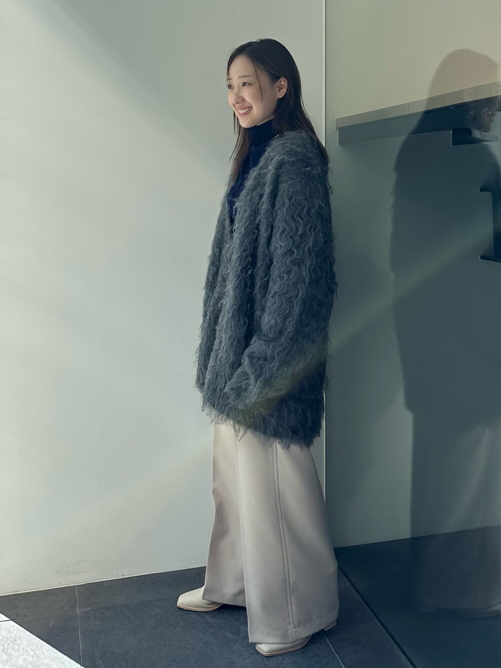 ブルー系のTシャツ/カットソー、ベージュ系のその他パンツ、グレー系のカーディガン/ボレロを着用したレディースの秋コーディネートの2枚目の写真