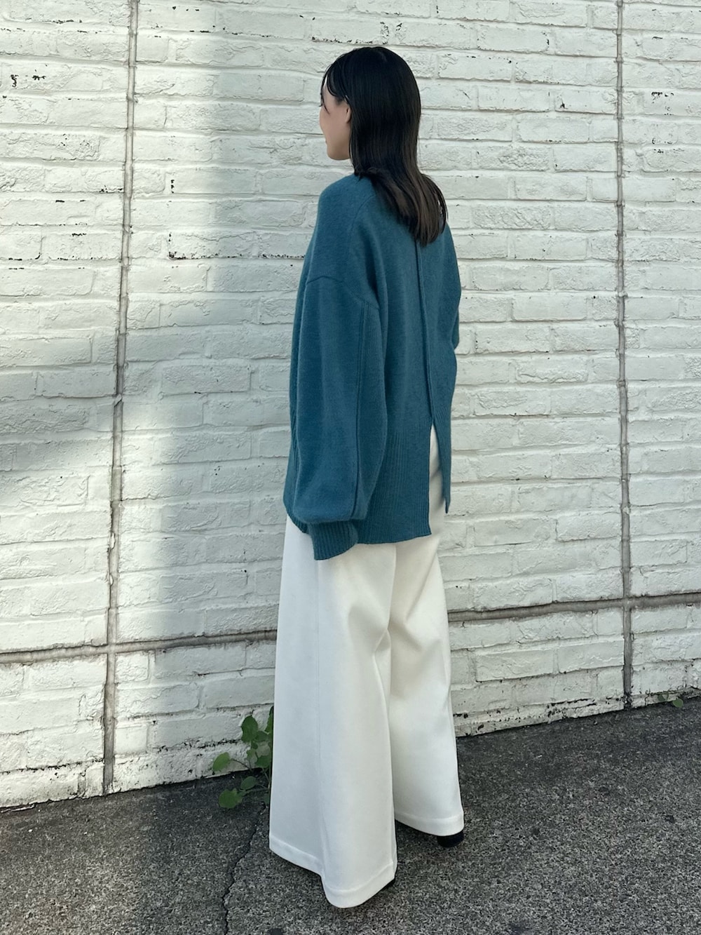 ベージュ系のスラックス、ブルー系のニット/セーターを着用したレディースの秋コーディネートの3枚目の写真